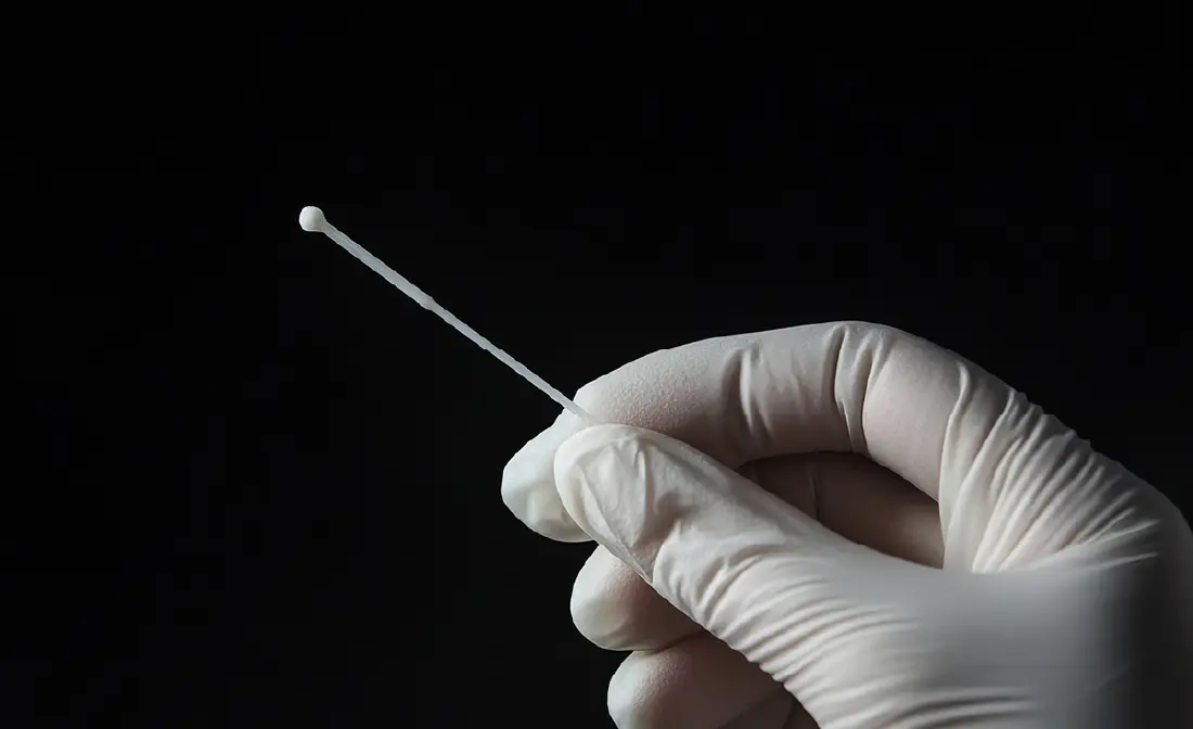 頬の内側に採取棒を当てて検査をする様子